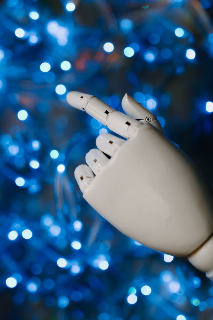 services-03 Close-up of a robotic hand with glowing blue bokeh background, symbolizing advanced technology.